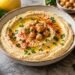 Creamy homemade hummus topped with chickpeas, herbs, paprika and olive oil